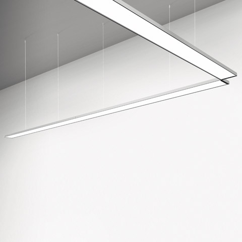 Artemide Pad System: sleek suspended linear LED luminaires in aluminum, arranged in an angular configuration, emitting diffused white light