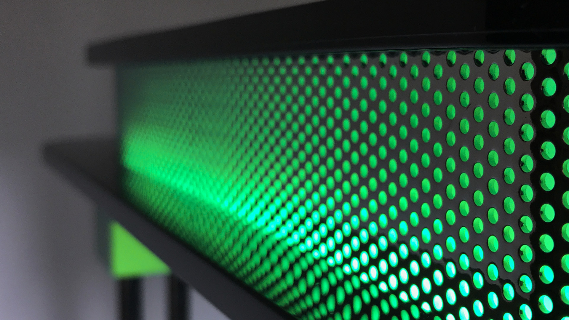 Artemide Pausania lamp detail: green perforated cylindrical diffuser with black circular top and bottom plates on chrome stem