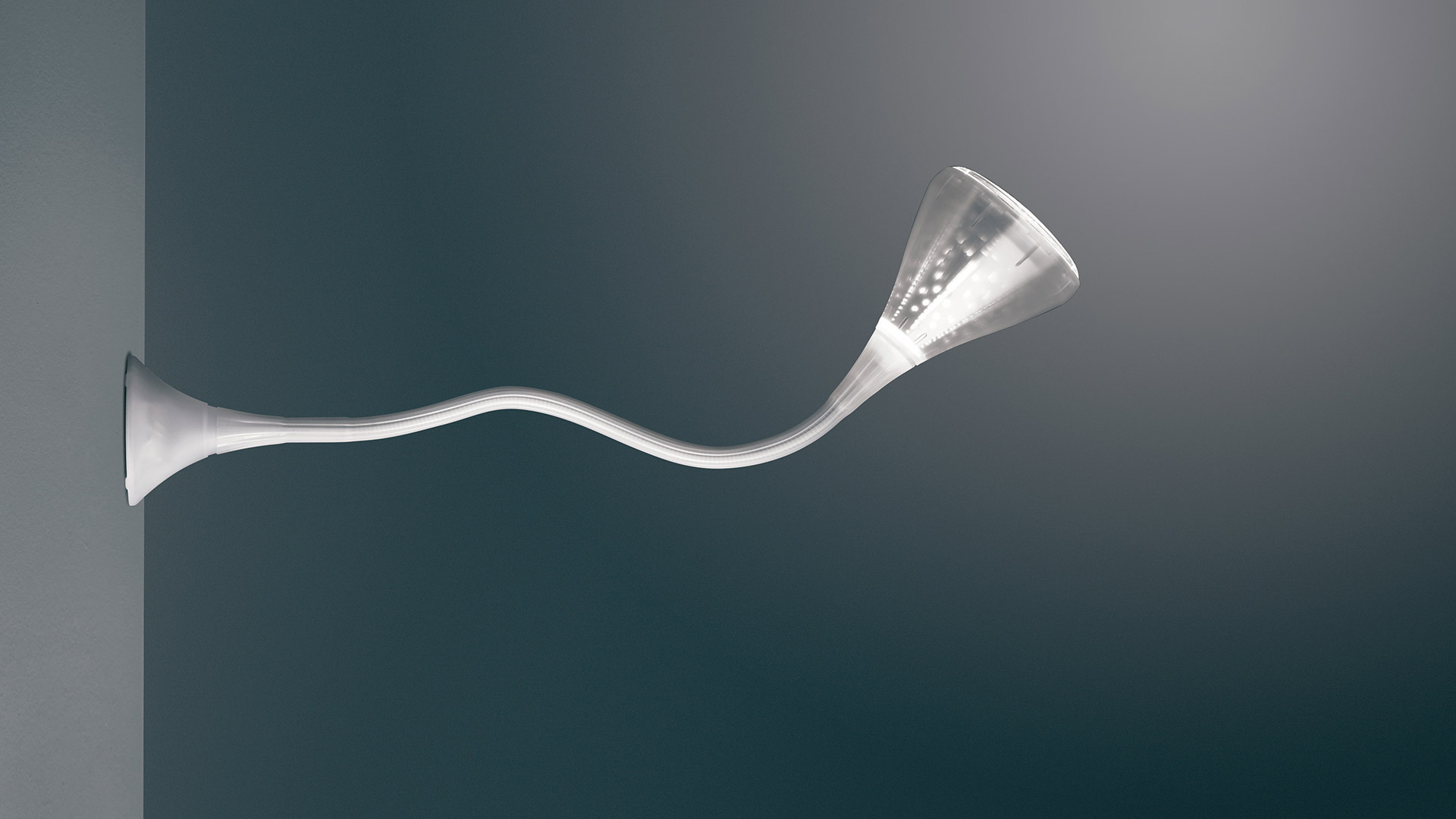 Artemide Pipe wall lamp: sinuous white arm extends from wall, ending in a flared trumpet-shaped LED diffuser emitting warm light