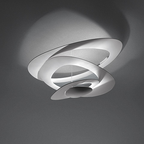 Artemide Pirce Soffitto ceiling lamp in white, featuring sculptural spiral diffuser casting dramatic shadows on the ceiling
