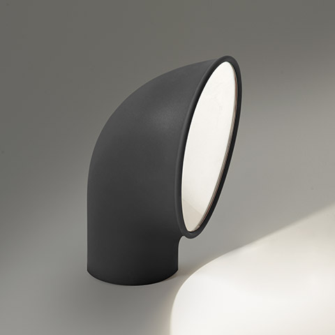 Artemide Piroscafo outdoor floor lamp: dark grey curved tubular body angled upward, emitting focused light from white circular diffuser