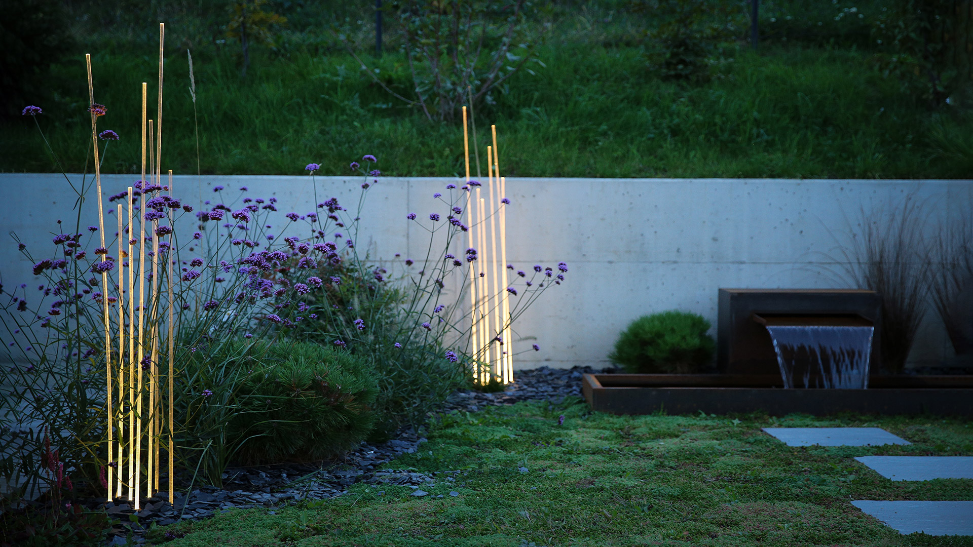 Artemide Reeds Outdoor floor lamps: two clusters of slender illuminated vertical stems rising from dark bases, evoking natural reeds