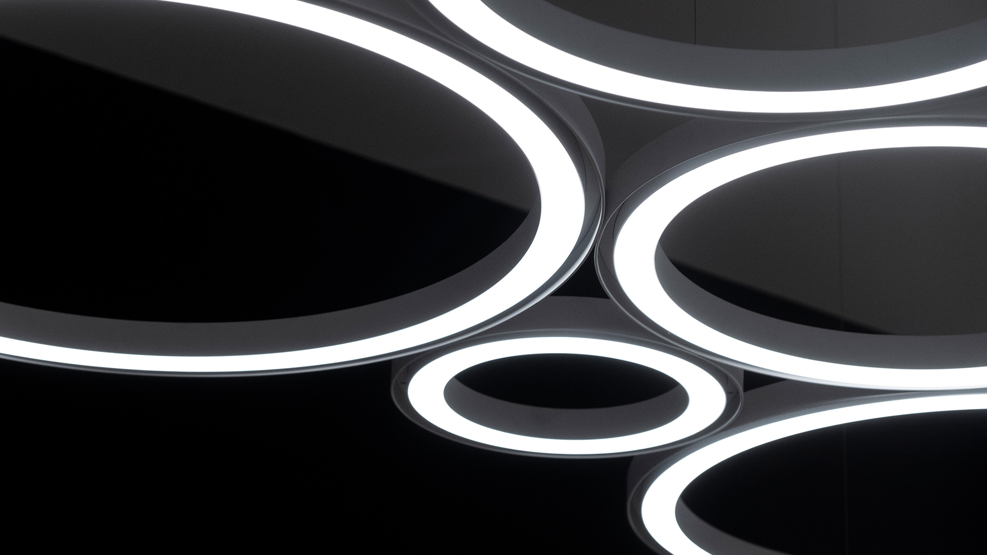 Artemide Ripple pendant lamp with cylindrical white fabric shade suspended over a round table with small decorative objects