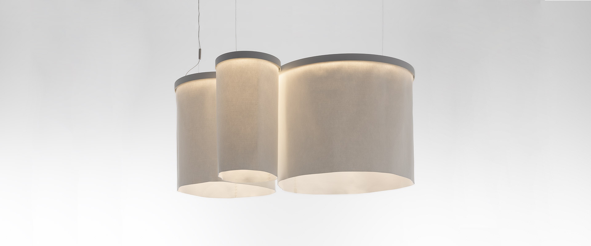 Artemide Ripple pendant lamp: large circular white ring with integrated LED light, suspended by thin cables against dark blue background