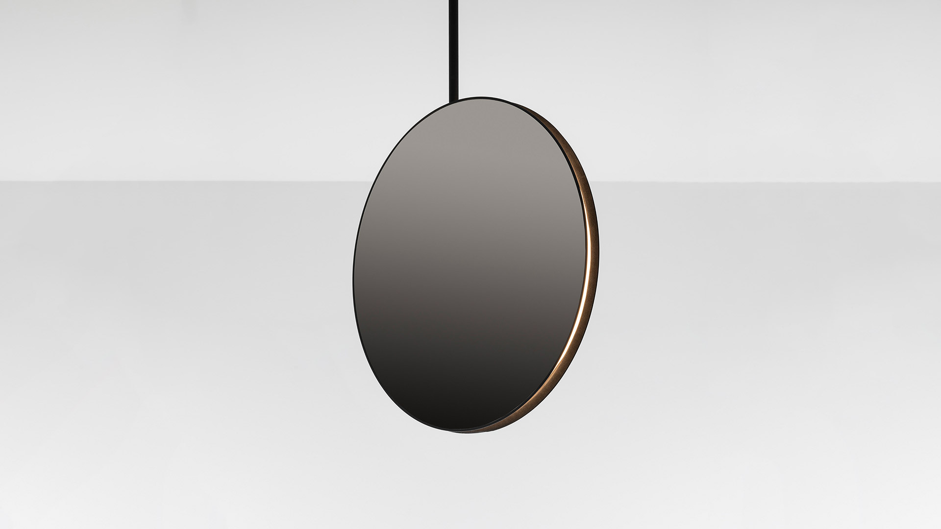 Three oval mirrors with dark metal frames reflecting blue sky and clouds; a pair of hands emerges from the central standing mirror
