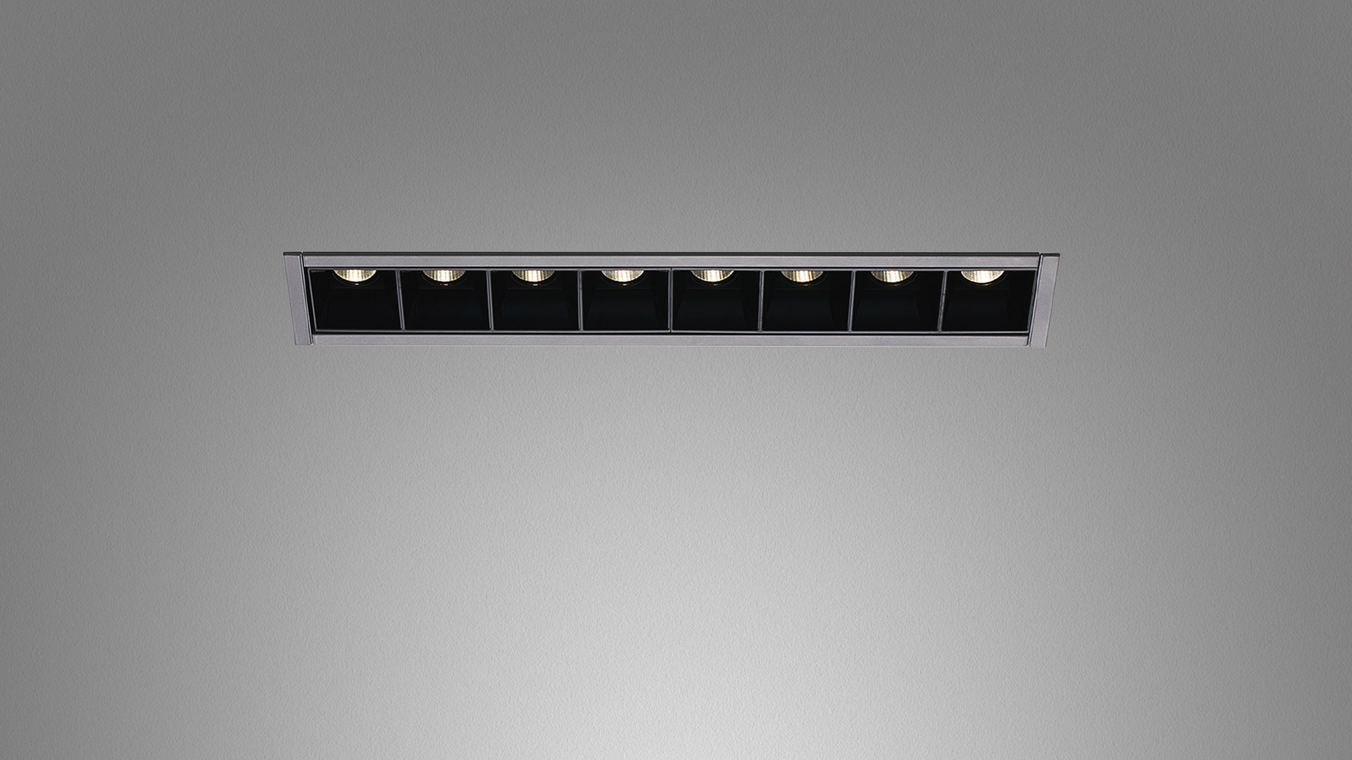 Artemide Sharp recessed linear ceiling light with 8 adjustable black-housed LED spotlights in a white trim frame