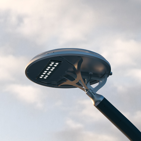 Artemide Solar Tree 2.0 street lamp: circular dark disc-shaped LED luminaire mounted on a pole, photographed from below against a cloudy sky