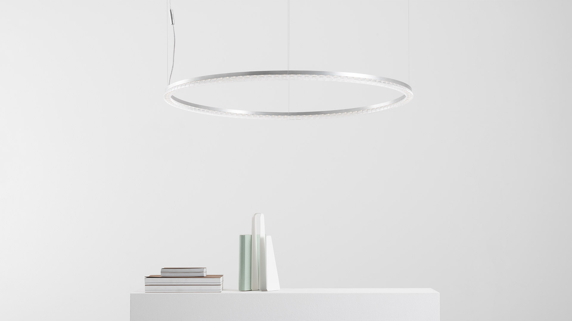 Artemide Somnĭum pendant lamp: large circular white LED ring suspended by thin cables above a minimalist white shelf