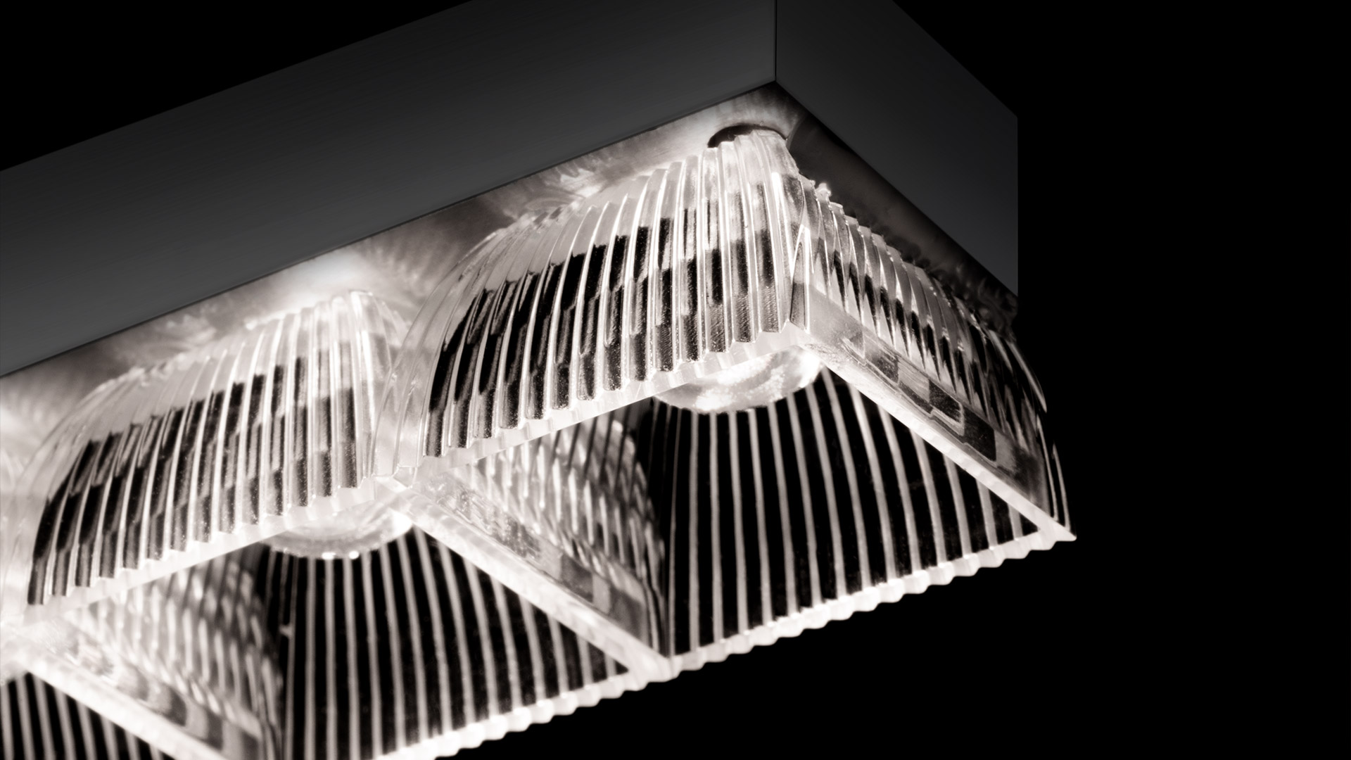 Artemide Somnĭum Stand Alone ceiling lamp with dual transparent ribbed diffusers emitting soft white light against dark background