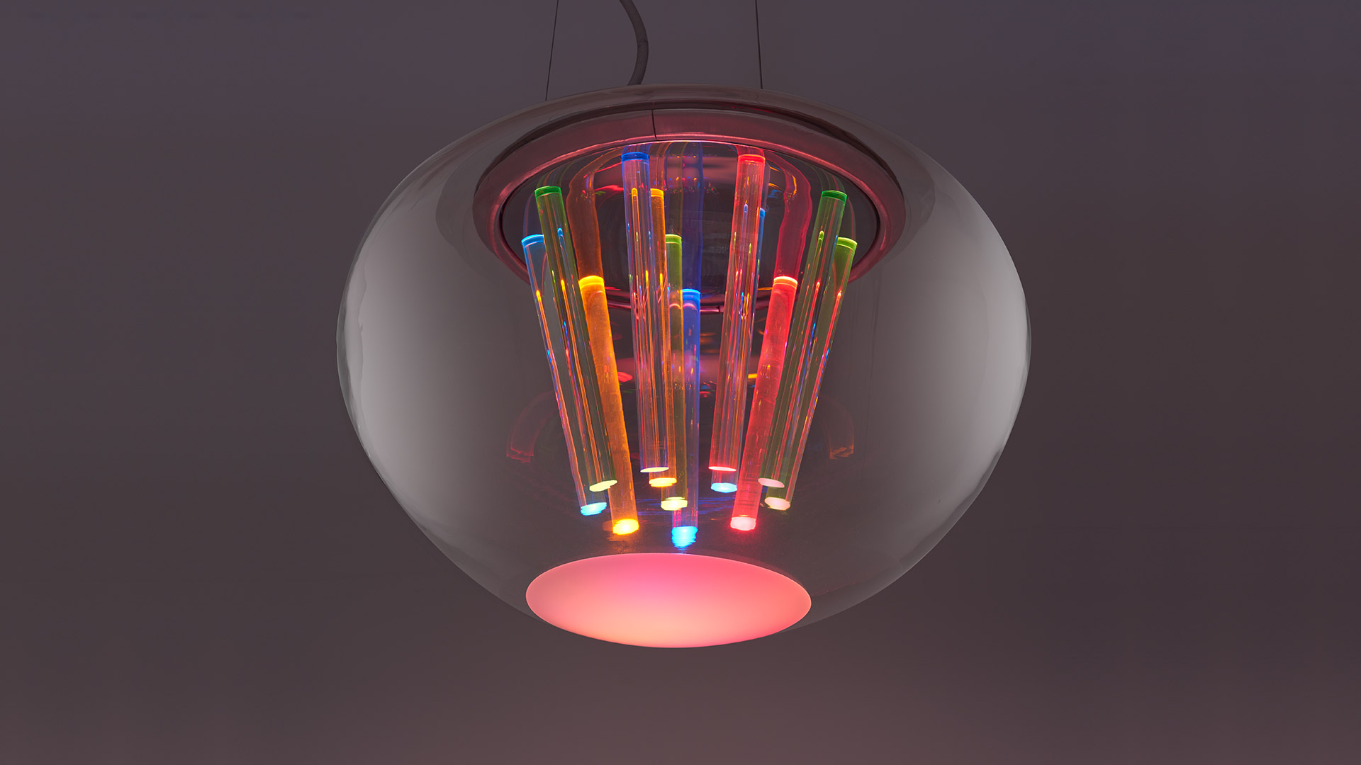 Artemide Spectral Light pendant lamp: translucent glass globe housing multicolored illuminated tubes emitting vibrant RGB light downward
