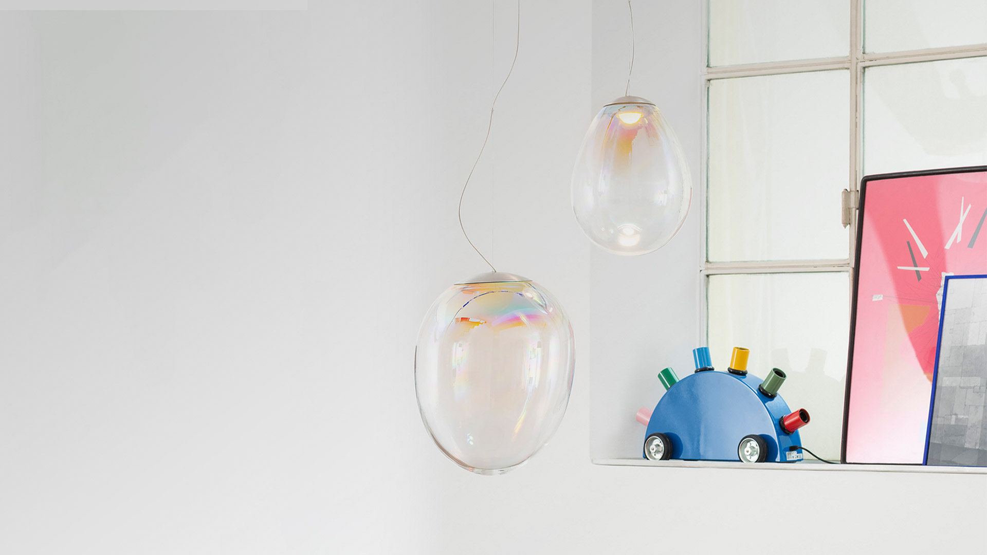 Four Artemide Stellar Nebula pendant lamps: transparent oval glass shades with iridescent multicolor reflections, hanging on thin cables