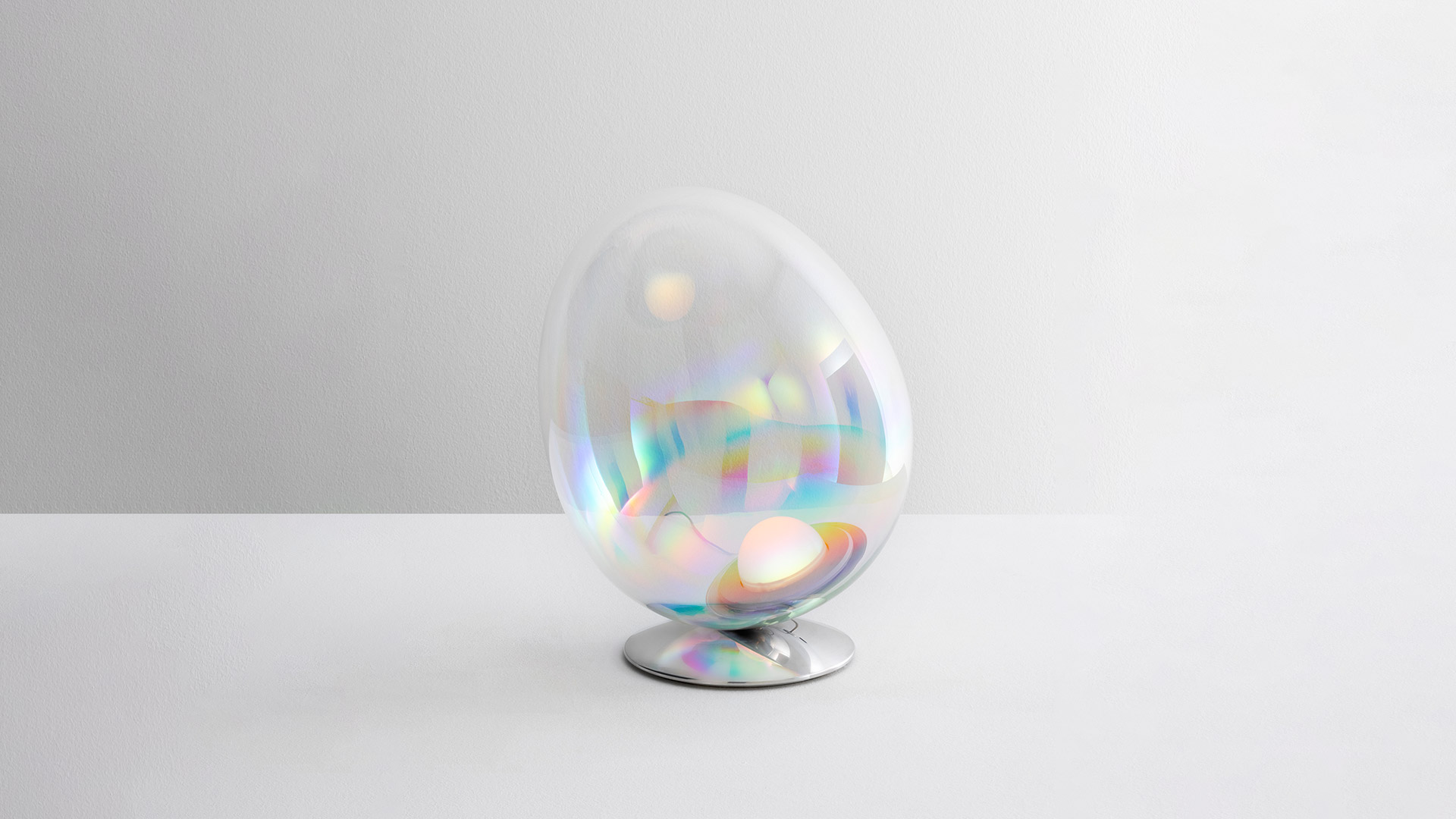 Artemide Stellar Nebula lamp: egg-shaped transparent iridescent diffuser with rainbow reflections on a polished chrome base