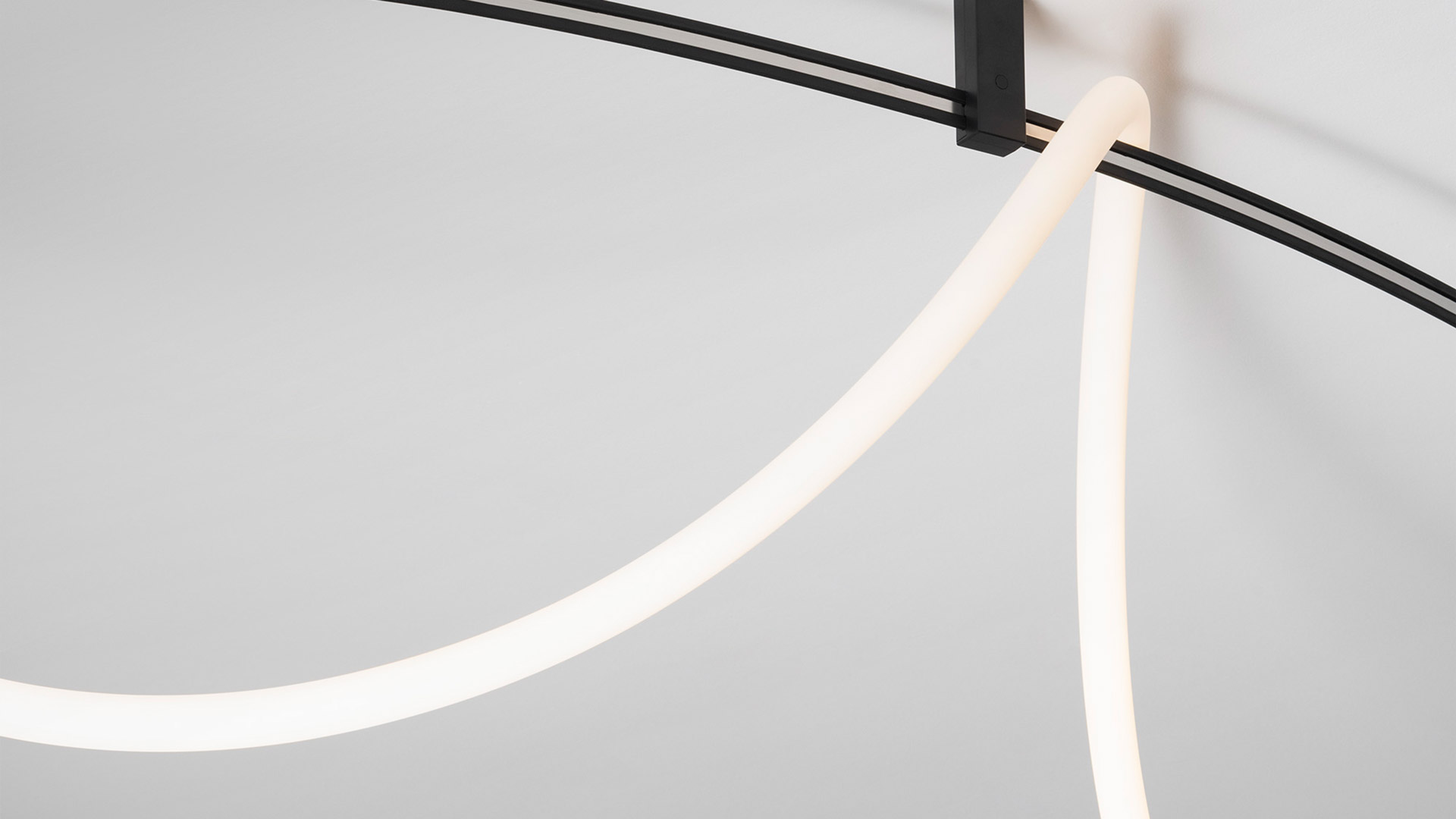 Artemide Sylt track lighting system in black: two adjustable spotlights and one linear LED bar mounted on a curved cable