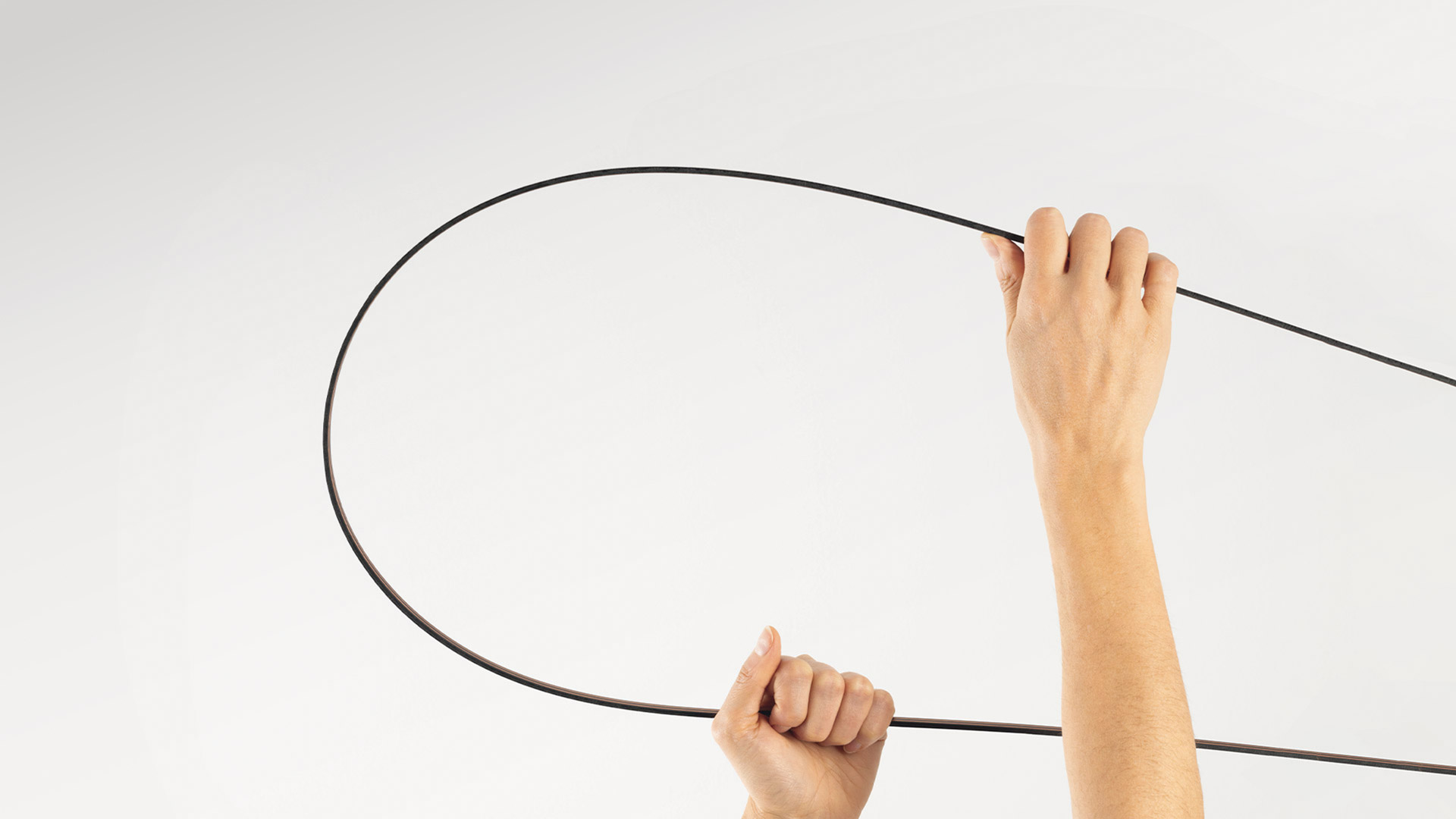 Artemide Sylt ceiling lamp: sinuous glowing white LED tube with dark metal track system mounted on white ceiling