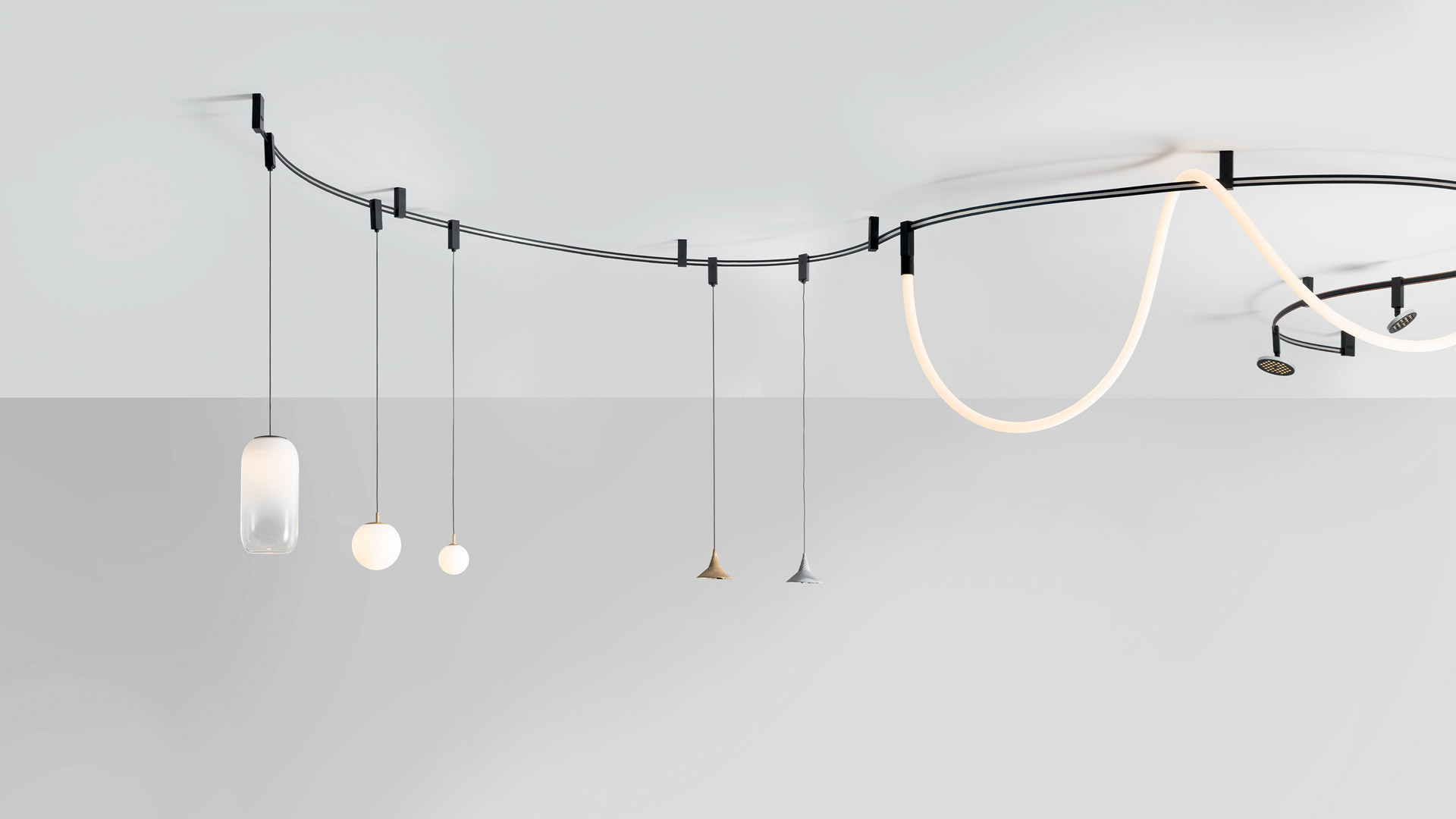 Close-up of Artemide Sylt lamp junction: matte black rectangular frame with copper braided cables running through the corner joint
