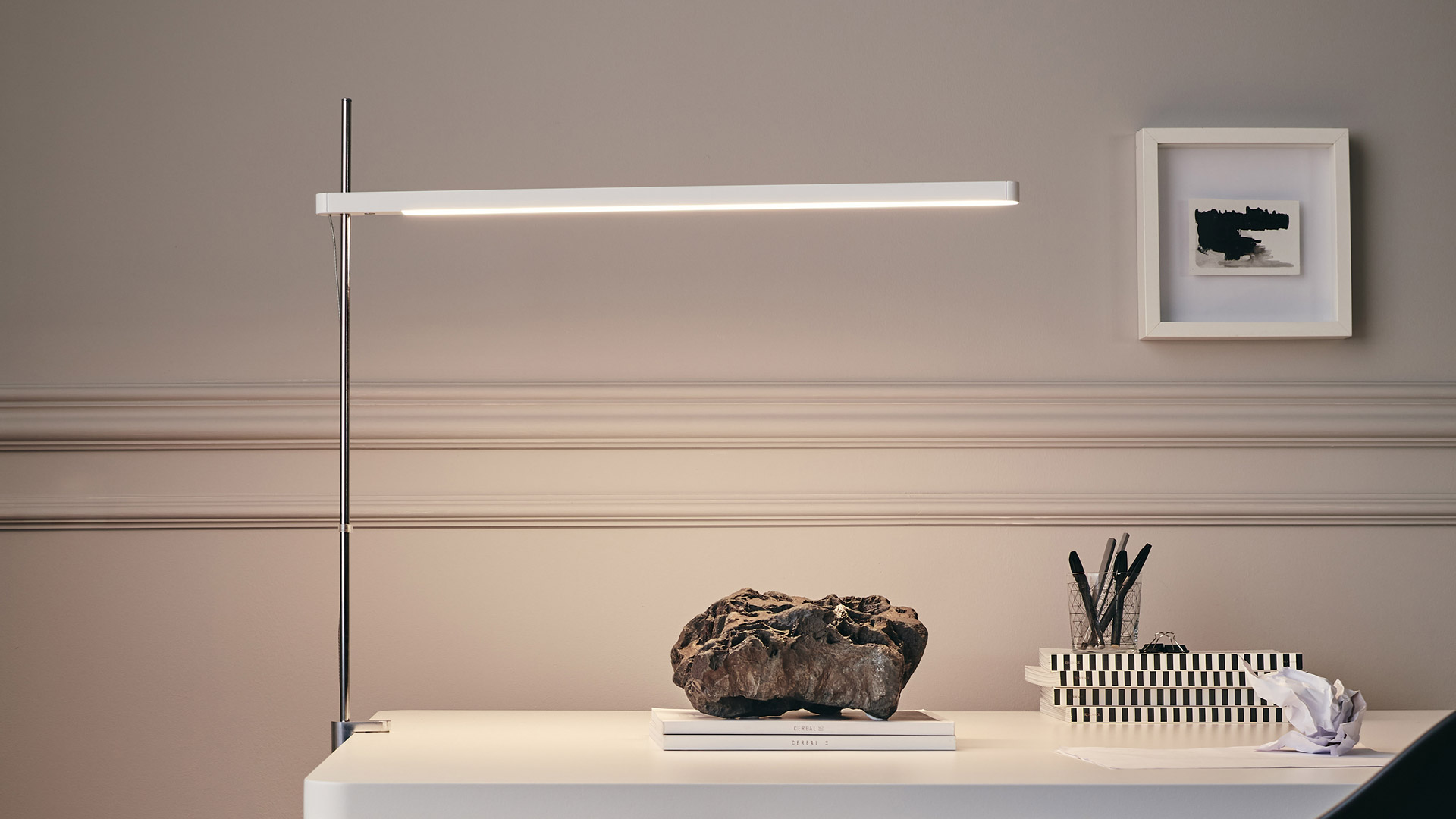 Artemide Talak table lamp shown in two positions: horizontal beam on left, angled beam on right, both with white round base
