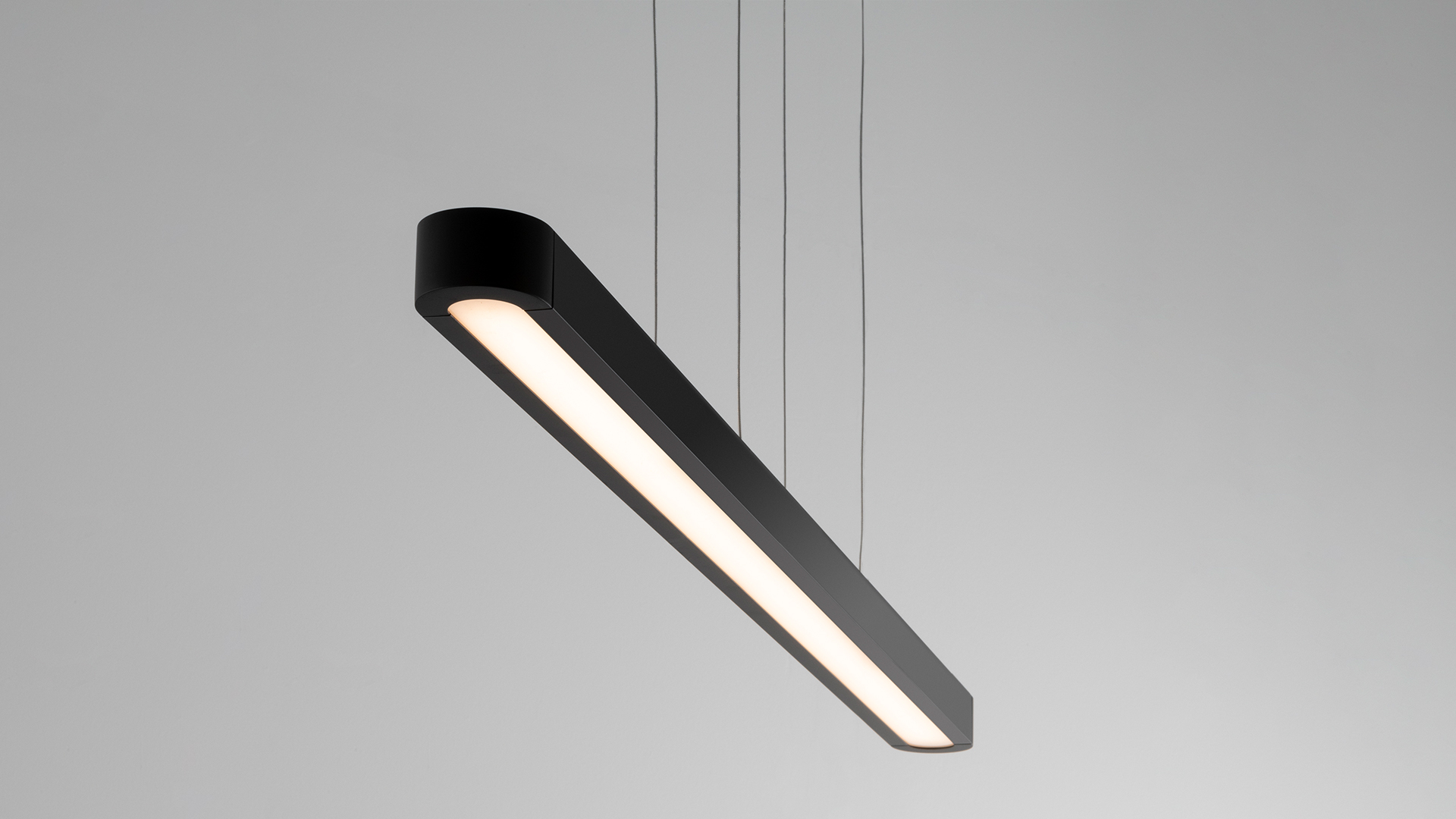 Talo suspension lamp by Artemide: sleek elongated aluminum profile with diffused white LED light, suspended by thin cables from ceiling