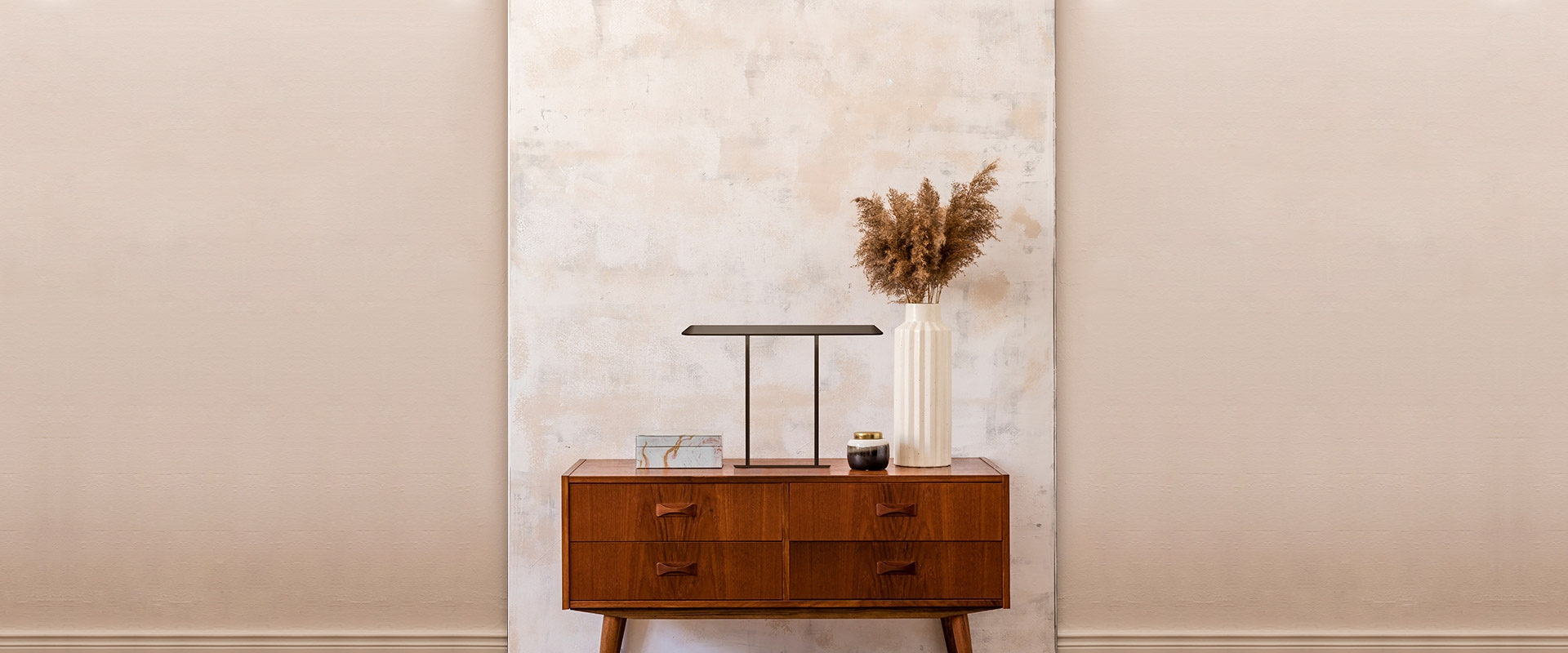 Artemide Tempio table lamp in dark bronze finish, minimalist U-shaped metal frame with flat rectangular shade, on wooden surface with wooden toys