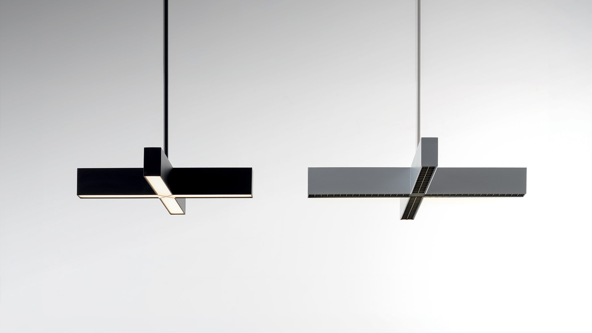 Three Artemide Tetras pendant lamps in cross shape: grey with black grid, white, and dark red, suspended from ceiling