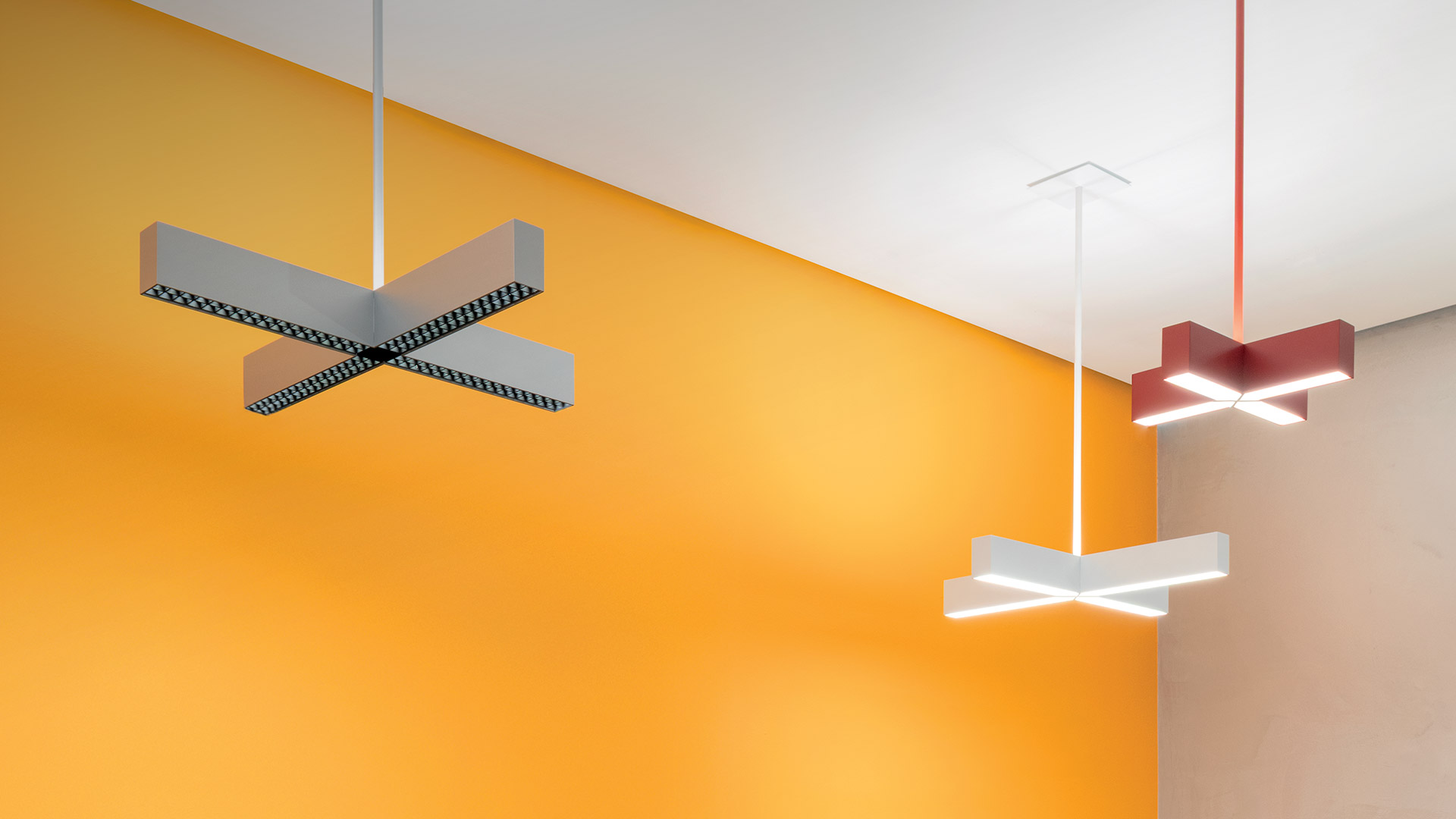 Artemide Tetras modular ceiling system with geometric white panels and warm LED light strips forming a cross-shaped pattern
