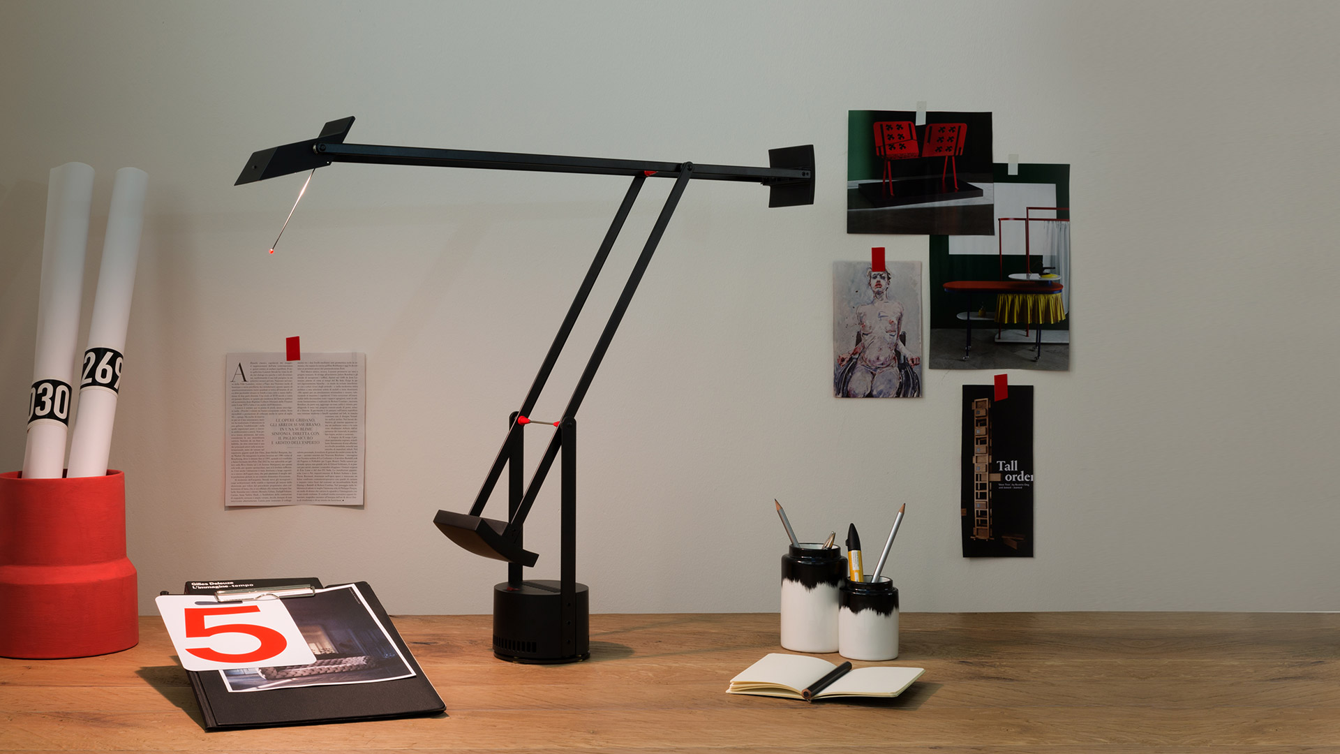 Three Artemide Tizio floor lamps in black, featuring iconic adjustable articulated arms and counterweight design, shown in various positions