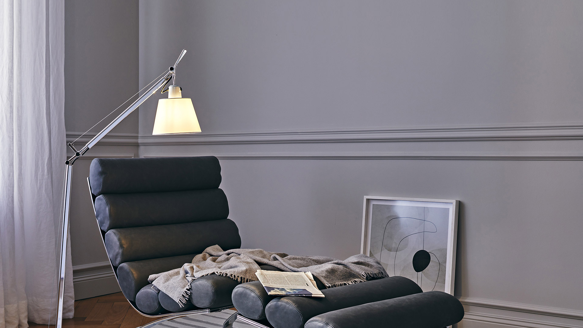 Artemide Tolomeo Basculante Reading Floor lamp with aluminum arm illuminates a dark chaise longue in an elegant gray room