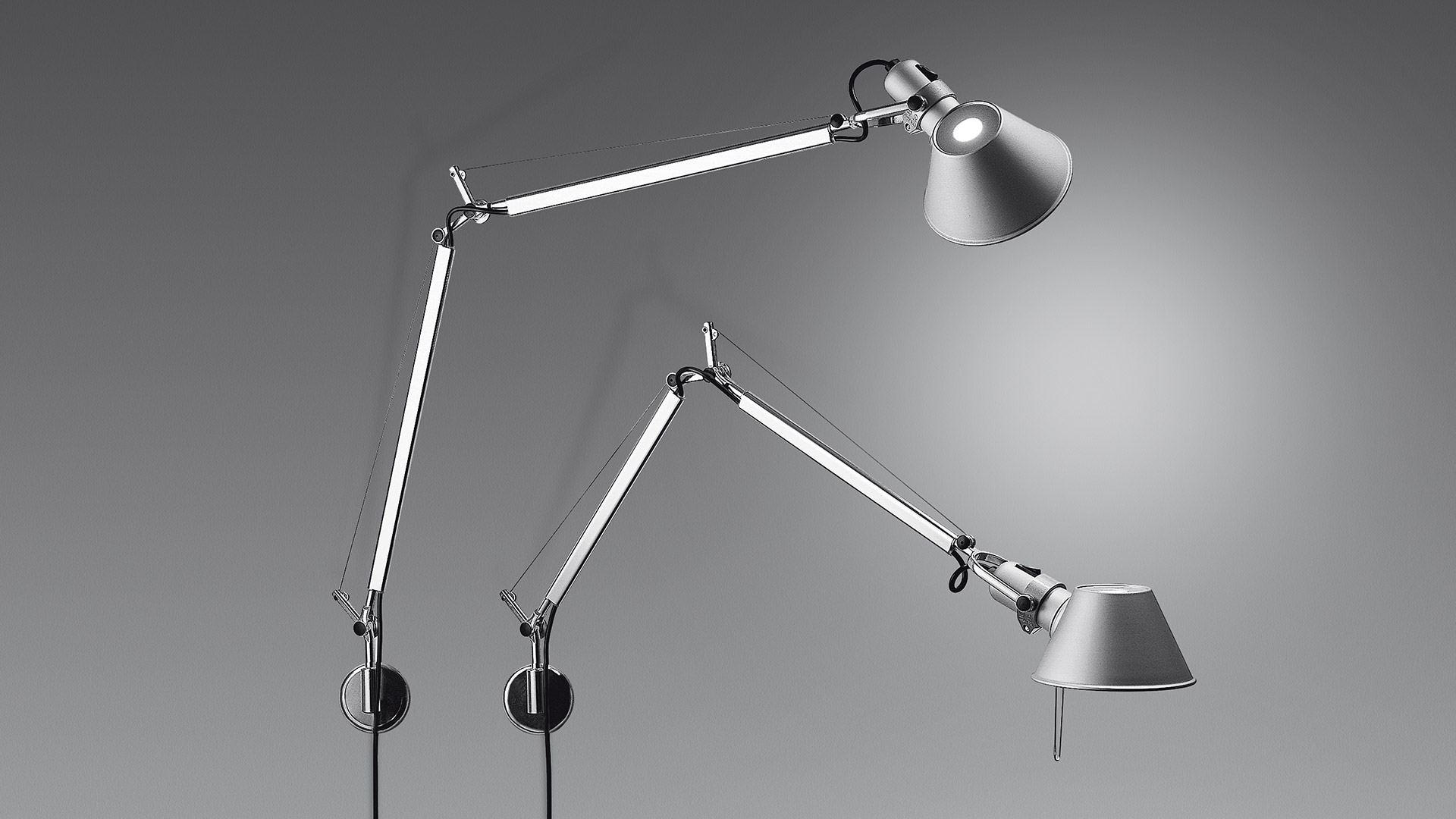 Artemide Tolomeo Parete and Tolomeo Mini Parete wall lamps in aluminum, featuring adjustable articulated arms and conical shades.