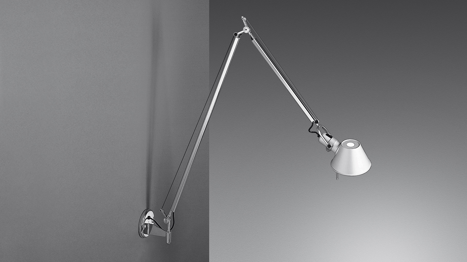 Artemide Tolomeo Parete wall lamp in aluminium with double articulated arm and conical shade, mounted on a grey wall