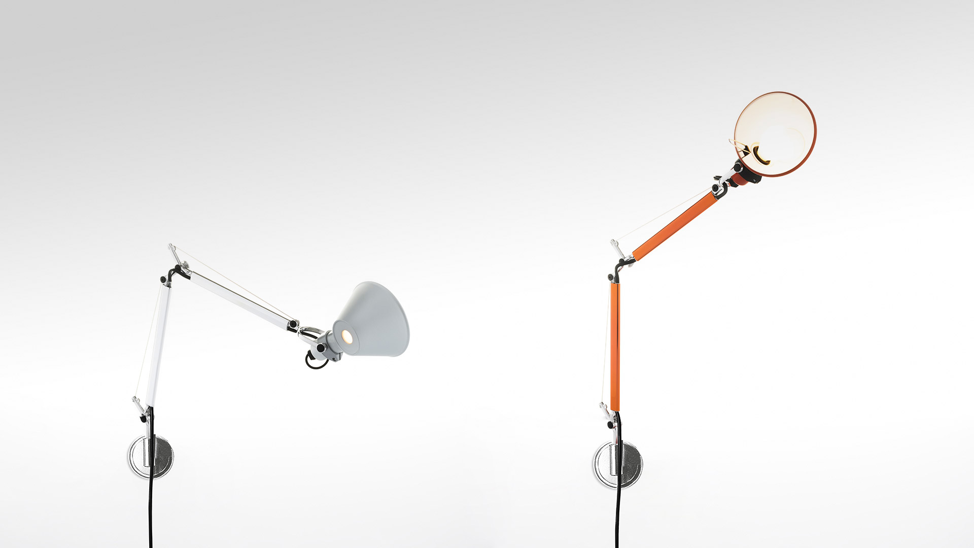Two Artemide Tolomeo wall lamps: left white with conical shade, right orange with circular diffuser, both on adjustable articulated arms