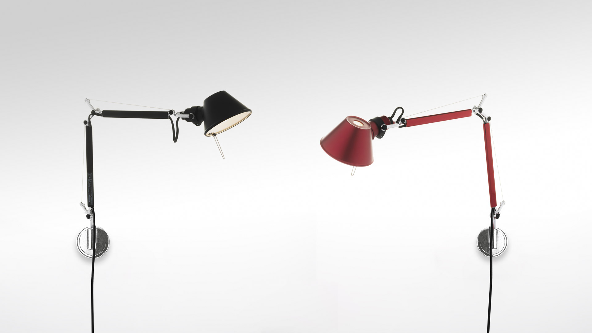 Two Artemide Tolomeo Micro Parete wall lamps: left in black, right in red, both with adjustable articulated arms and conical shades