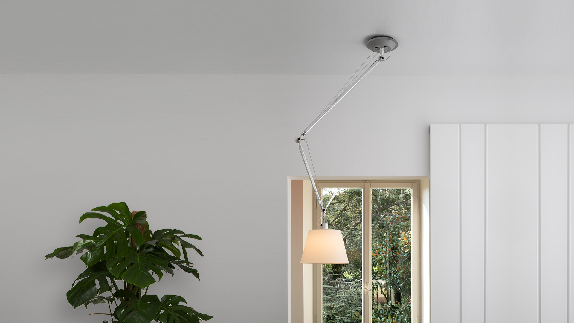 Three Artemide Tolomeo pendant lamps with adjustable aluminum arms and conical shades: two aluminum, one white fabric