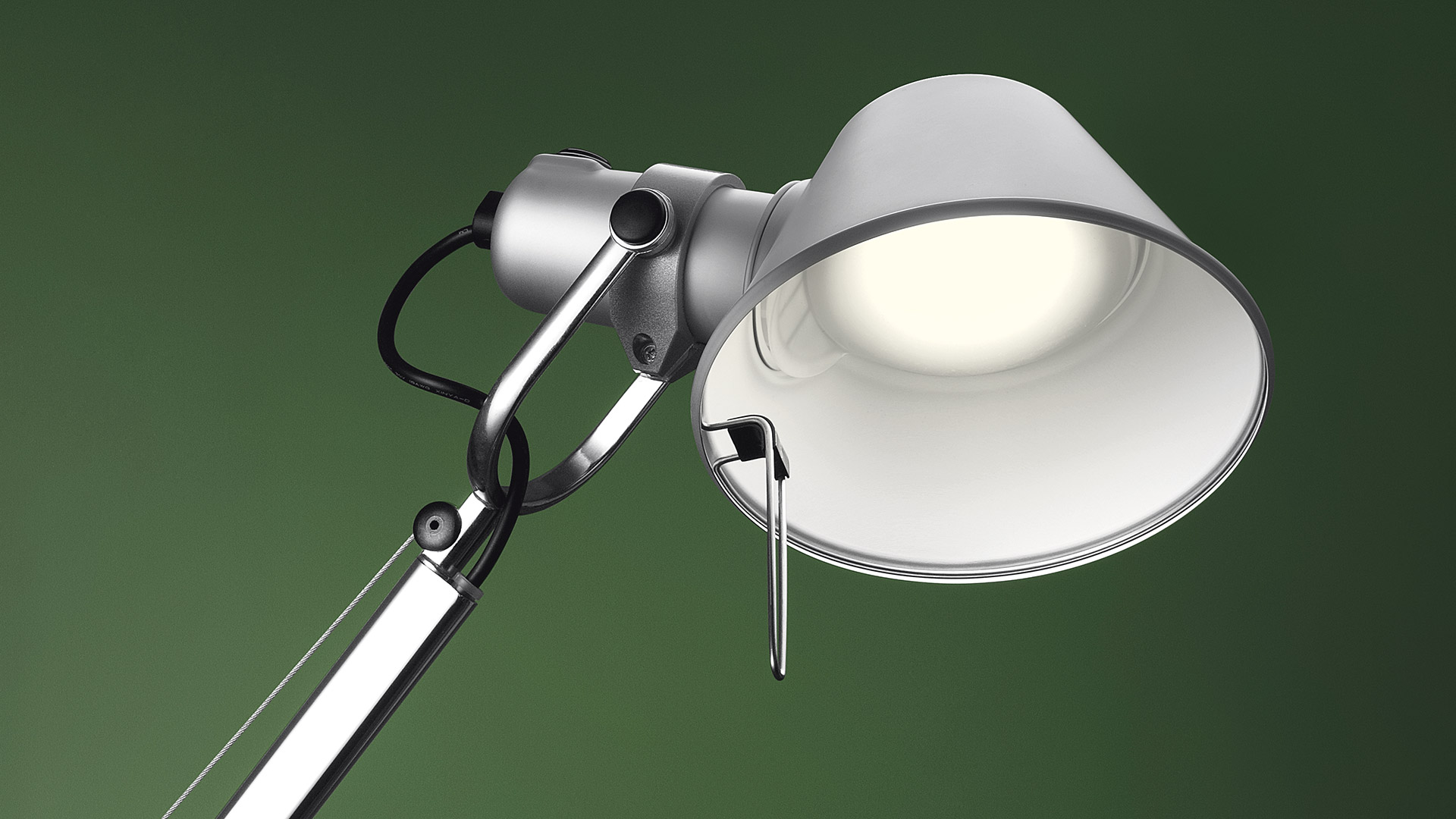 Two Artemide Tolomeo Tavolo desk lamps: left white with articulated arm, right black with angled arm on round base
