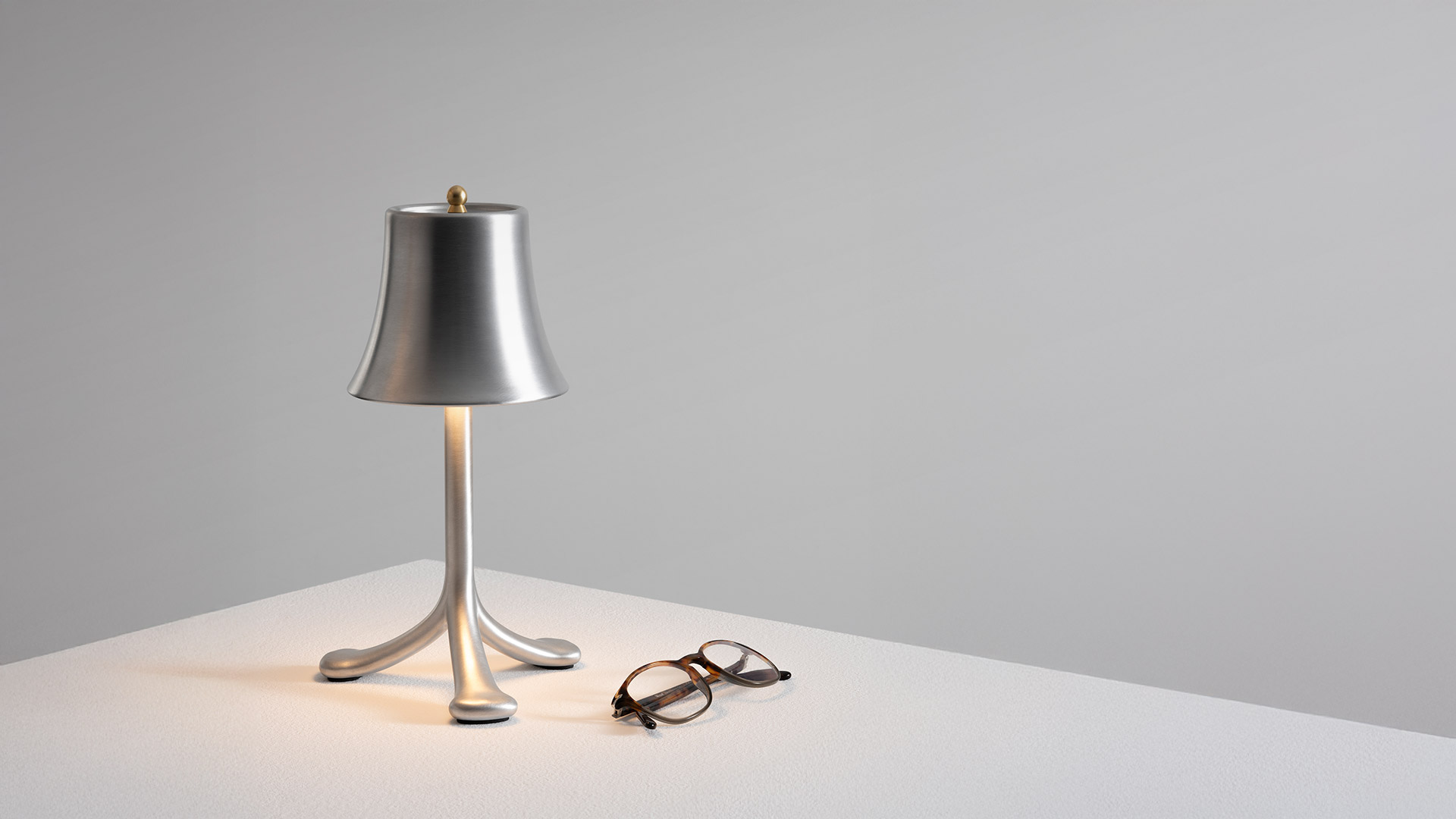 Three Artemide Trois Rois table lamps with tripod bases and bell shades in silver, burgundy, and purple velvet finishes