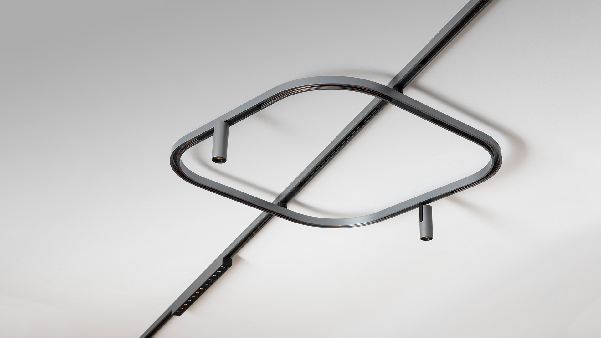 Artemide Turn Around System: flexible LED light strip in silver profile, curving along a wall corner with a dark mounting bracket