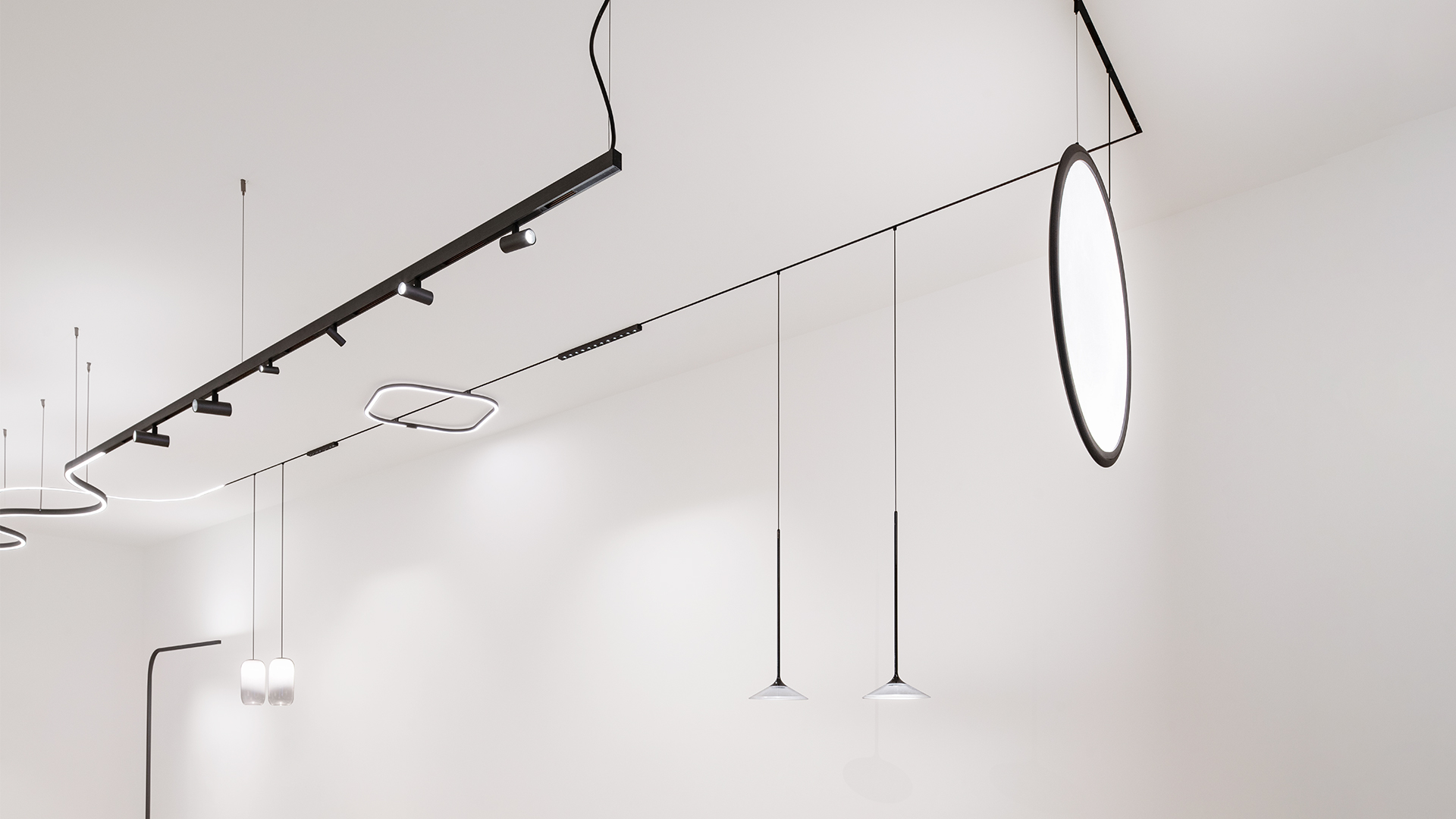 Artemide Turn Around System: square-shaped LED pendant lamp with rounded corners in polished metal, suspended by a black cable from ceiling