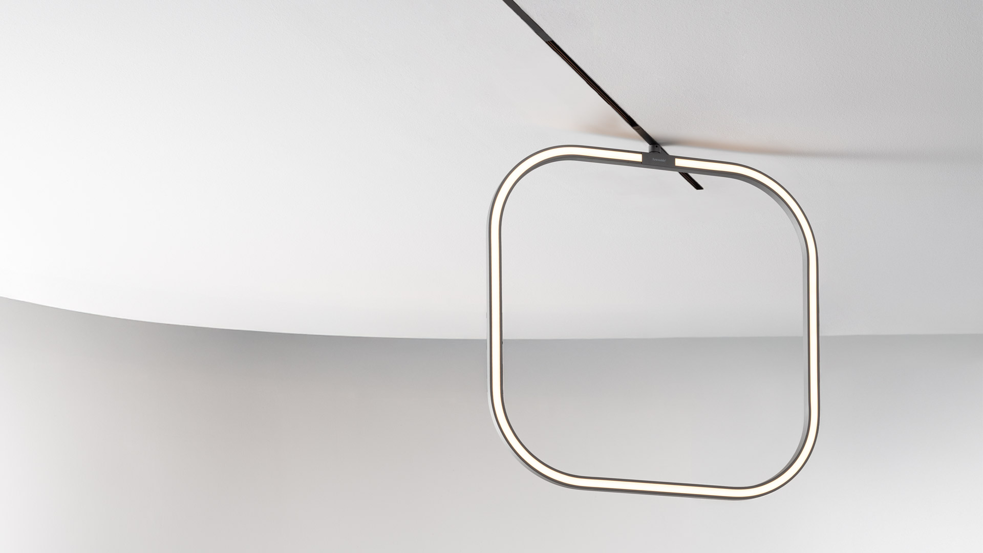 Artemide Turn Around System: curved dark track suspended from ceiling with spotlights, linear LED bar, and three pendant lights