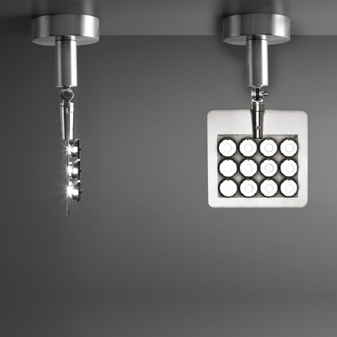 Two Artemide Una Pro ceiling spotlights: left rotated showing LED array, right facing down displaying 4x4 LED grid on square aluminum head