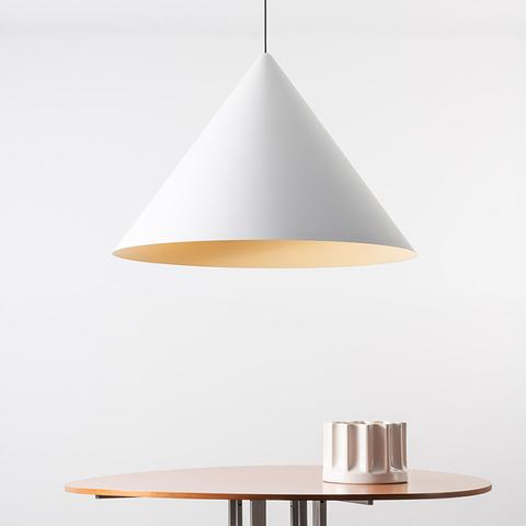 Vea Suspension pendant lamp by Artemide: white conical shade with warm gold interior, hanging over a round wooden table