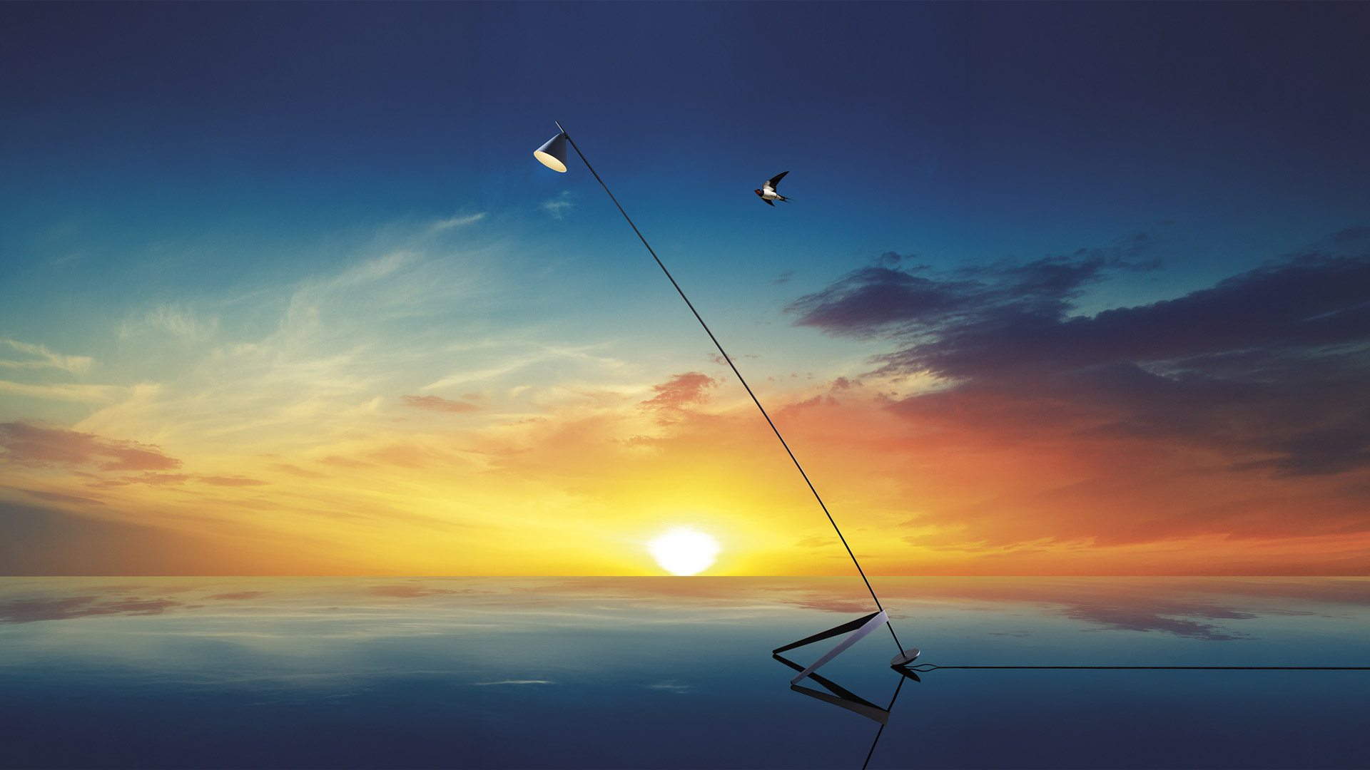 Artemide Vea floor lamp with tall angled black stem illuminates an outdoor dining table and chairs at dusk by the sea