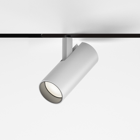 Artemide Vector Magnetic track spotlight in white, cylindrical body mounted on black magnetic track, tilted LED head