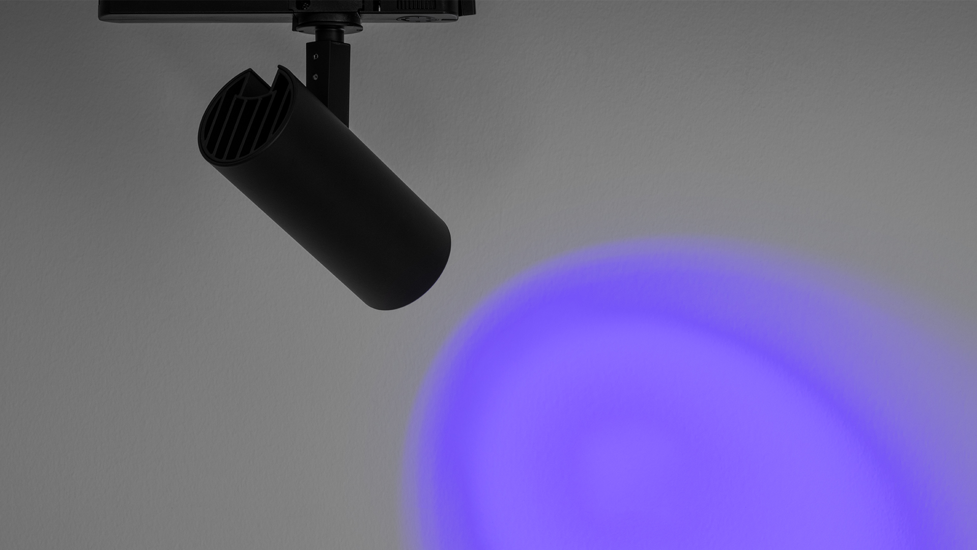 Three Artemide Vector Track 230V spotlights on rail: black, white, and silver cylindrical heads, adjustable orientation