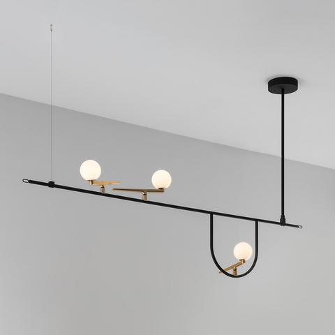 Artemide Yanzi pendant lamp: black horizontal bar with three opal glass globe lights on brass fittings, suspended from ceiling