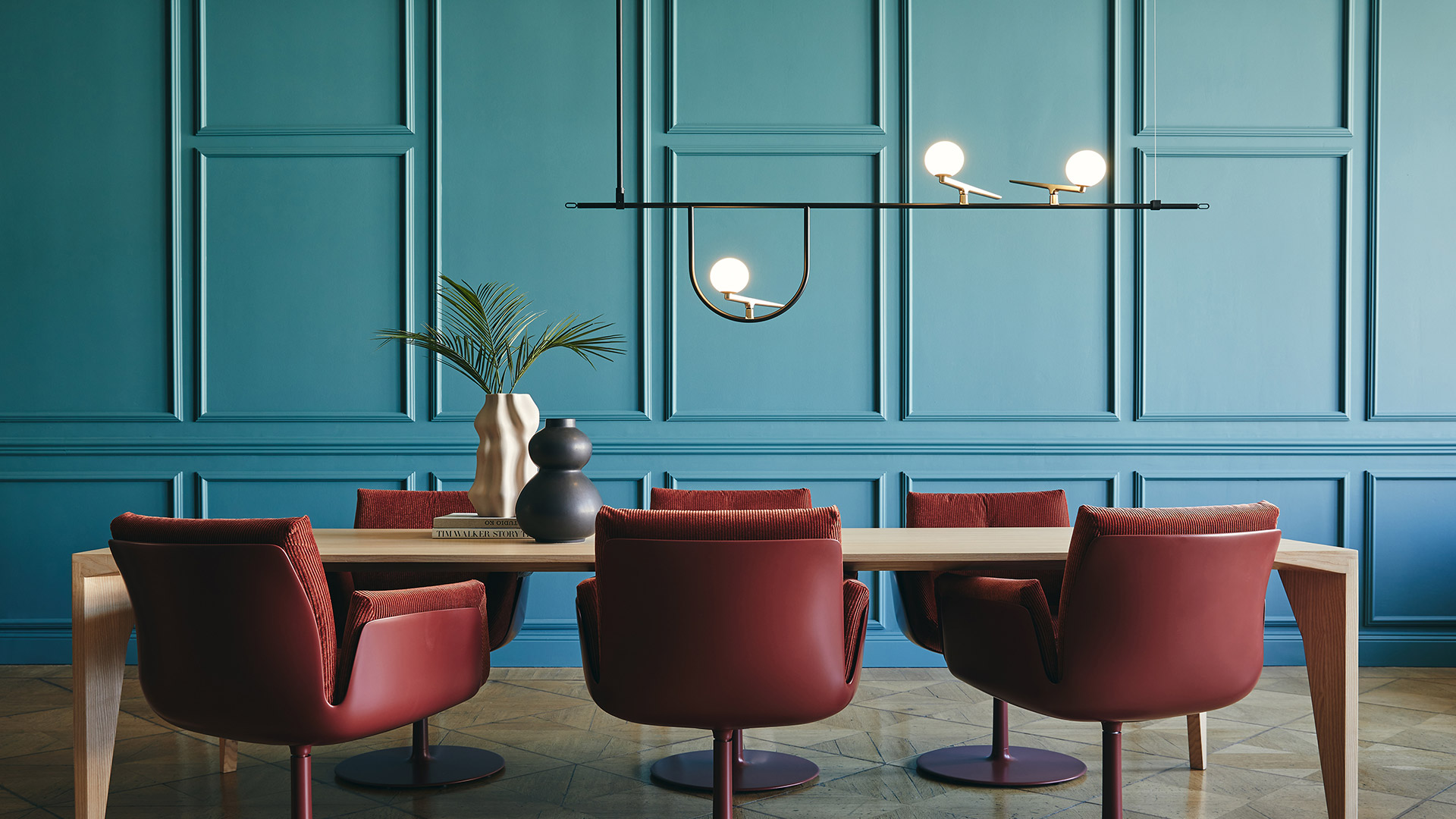 Artemide Yanzi table lamp with brass arm and opal glass sphere on colorful terrazzo surface beside limes on wooden tray
