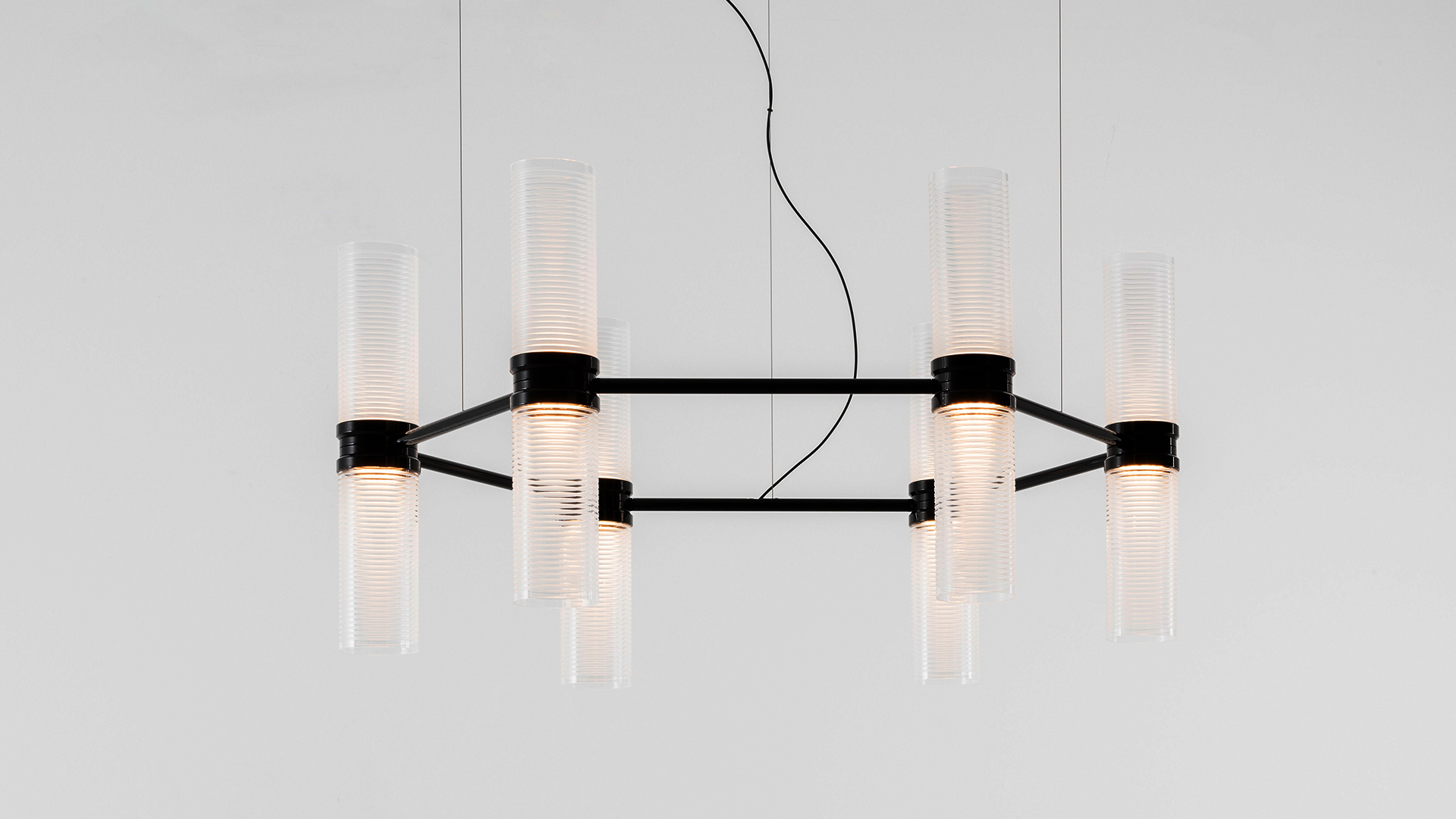 Artemide Zephyr pendant lamp: six vertical cylindrical glass diffusers mounted on a horizontal dark bronze metal bar