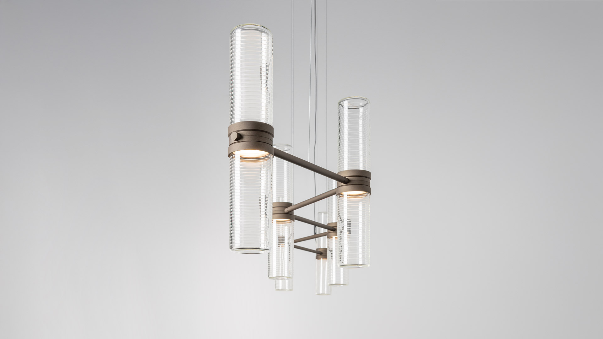 Artemide Zephyr chandelier: matte black arms holding cylindrical ribbed glass diffusers pointing downward, elegant modern design